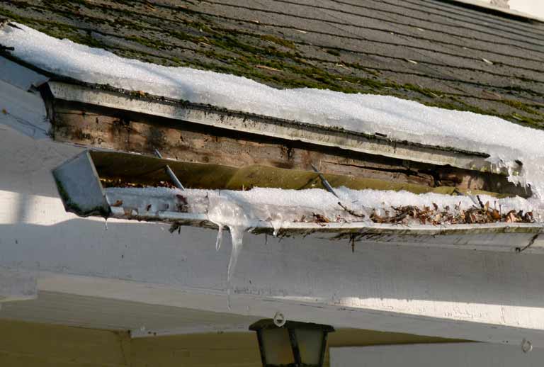 Clogged gutter falling away from home